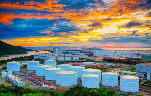 Industrial storage tanks at sunset